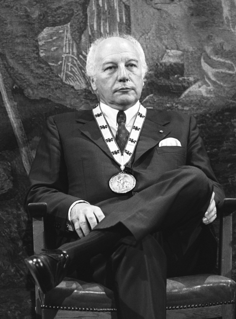 Walter Scheel sitzt mit einer Medaille um den Hals
